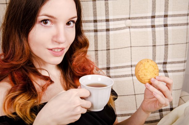 美丽美丽的公主，一头卷发，戴着皇冠，穿着绿色紧身衣，喝着英国茶图片下载