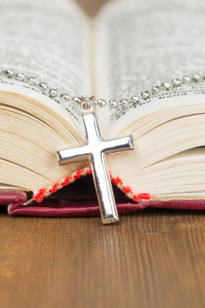 木桌上的银十字架项链和打开的圣经图片下载