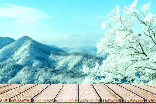 空荡荡的木板桌面前面是模糊的雪山景观背景。透视木材在模糊的冬季景观背景照片蒙太奇，产品展示或模拟您的产品。图片下载