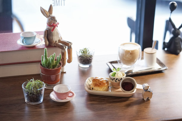 烤饼和凝结奶油。一组下午休息时间，柔软地专注于烤饼，凝结奶油，背面还有一杯模糊的卡布奇诺。图片下载