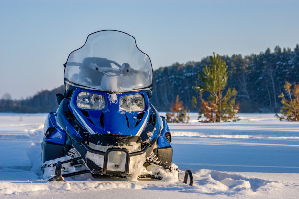 雪地上的雪地摩托，背靠森林。寒假的自然休闲理念。冬季运动。图片下载