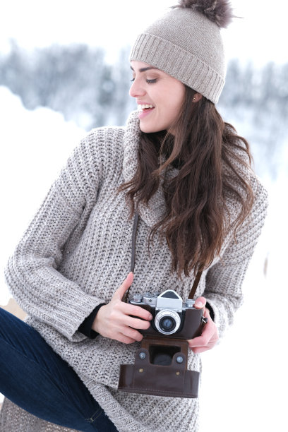 美丽的女孩在山上拍照。冬天的季节。图片下载