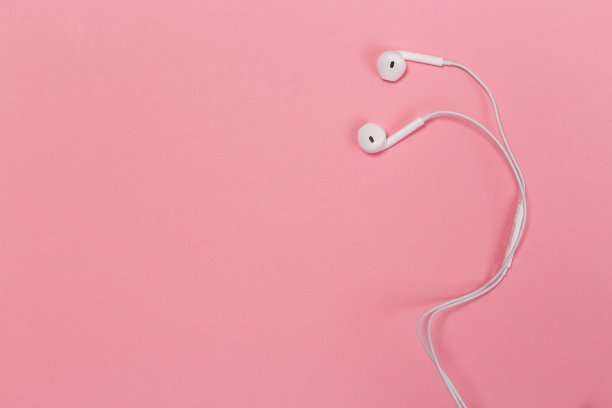 彩色背景上的耳机。粉色背景的白色耳机。前视图。平的。副本的空间。时尚的彩色照片。以彩色纸为背景的简约风格。音乐的概念图片下载