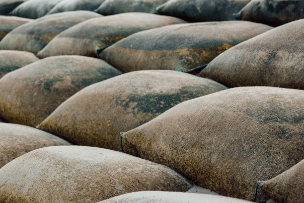 海滩上沙袋墙的特写，沙袋保护海岸免受海浪侵蚀图片下载