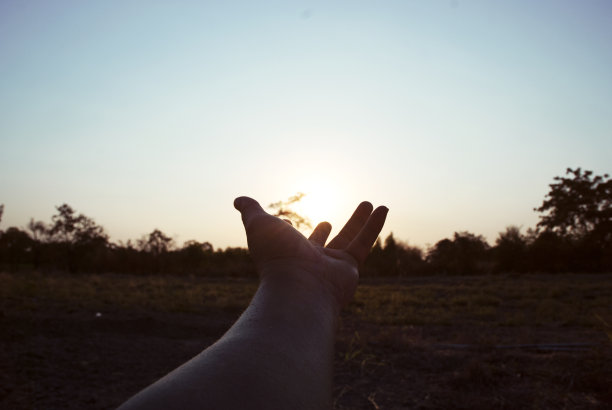 手握天空，傍晚日出。图片下载