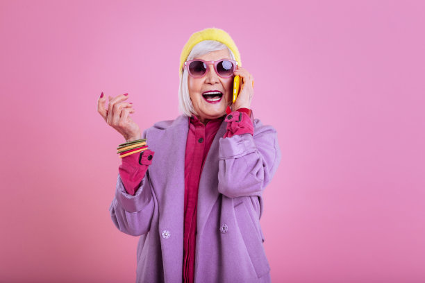 情绪化的老妇人粉红色的嘴唇和指甲打电话给她的朋友图片下载