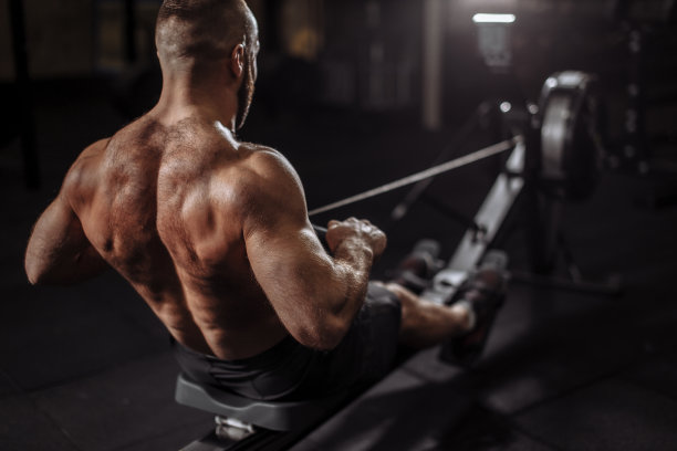近的背影查看照片。赤膊男在俱乐部使用模拟训练图片下载