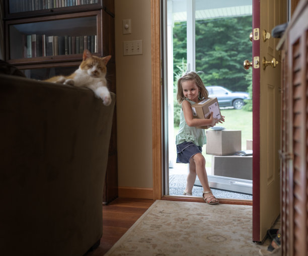 快乐的小女孩带来送货上门的包裹-送货上门和网上购物的概念图片下载