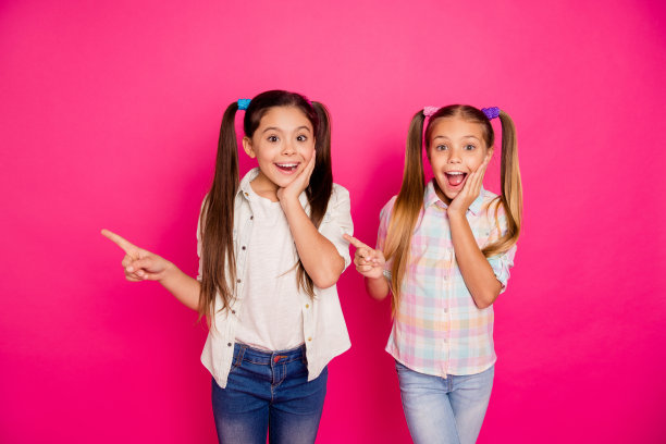 特写照片两个小的小的年龄，她，她的女孩好奇的姐妹显示空的空间点方式方向手指穿着休闲牛仔裤牛仔格子格子衬衫孤立的玫瑰充满活力生动的背景图片下载