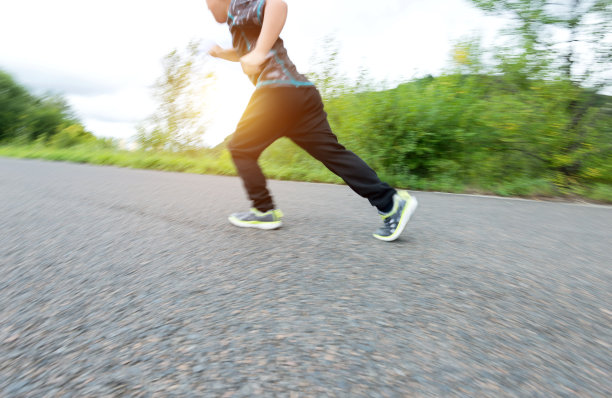 男孩在公园的小路上奔跑图片下载