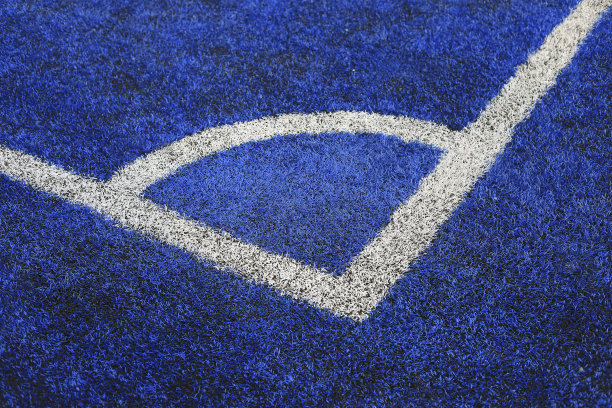 体育的概念。足球或足球场，草皮角角蓝色背景与拷贝空间。——图片图片下载