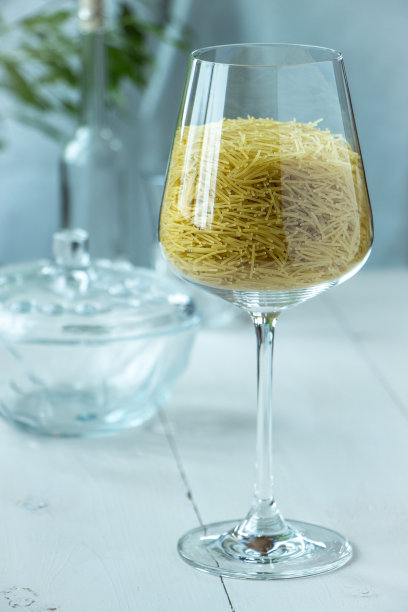 玻璃小意大利面，以乡村风格为背景，绿色和白色。新鲜，简单，明亮的意大利风格食物照片图片下载