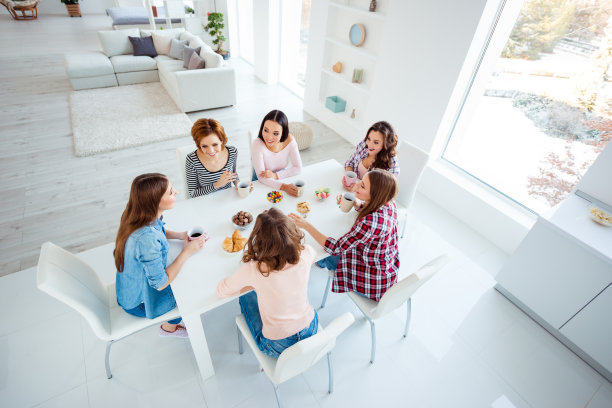靠近顶部，在高角度上看照片，美丽的她，她的女士们，喝热饮料，最好的朋友，围坐在大桌子，明亮的厨房，听谣言，新闻，秘密，女孩，白天，晚上，假期在室内图片下载