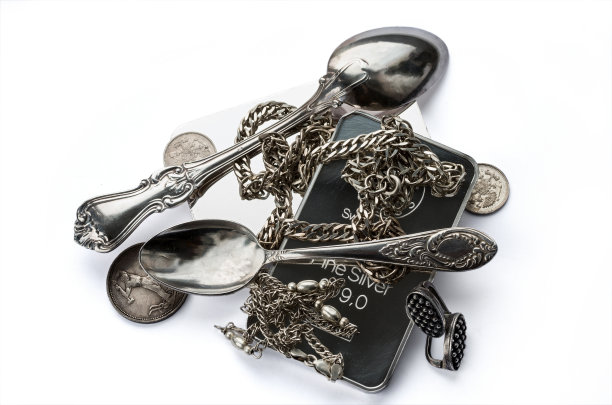 一堆金银条、银器、珠宝和古币。银器孤立在白色背景上图片下载