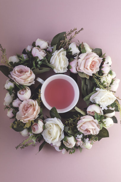 茶杯，茶和玫瑰在粉红色的背景上图片下载