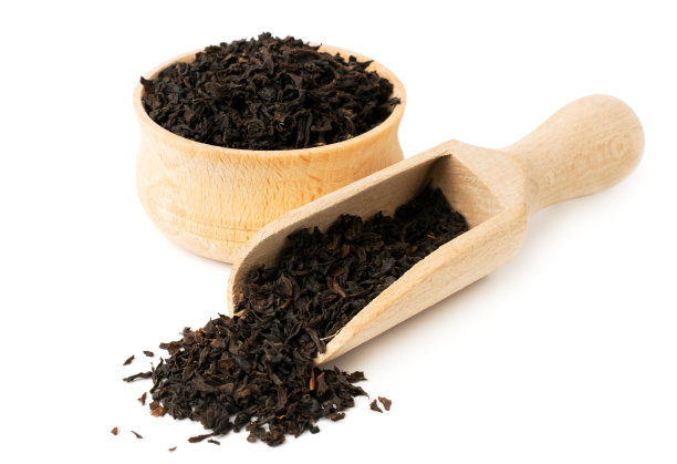 红茶的叶子在木盘和勺子上放一份白色图片下载