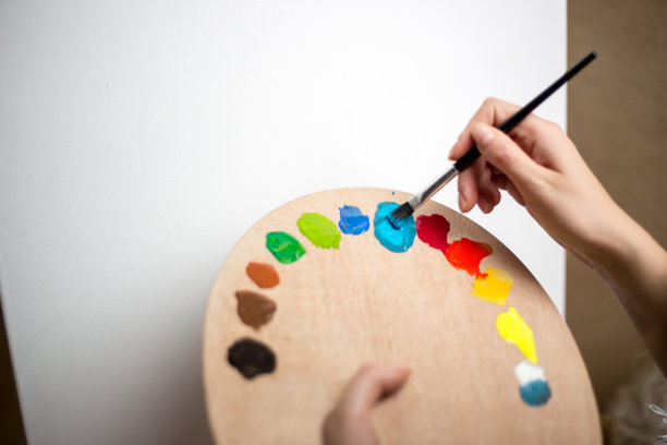 快乐的年轻女子在画布上作画图片下载