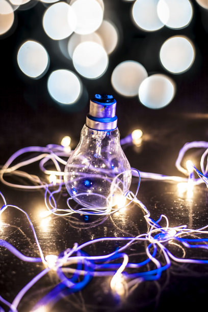 一个灯泡的近距离与彩色模糊的背景或圣诞灯与它。图片下载