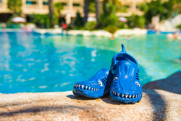 孩子们的防水木屐站在池边。图片下载