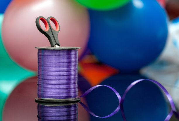 剪刀和紫色的washi胶带在模糊的彩色气球。副本的空间。有选择性的重点。手工和艺术创意。用于设计和装饰图片下载