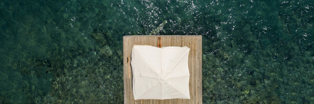 美丽的女人在海上木制码头上独自日光浴航拍照片图片下载