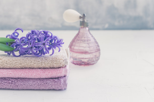 堆叠的彩色浴巾与风信子花在光的背景图片下载