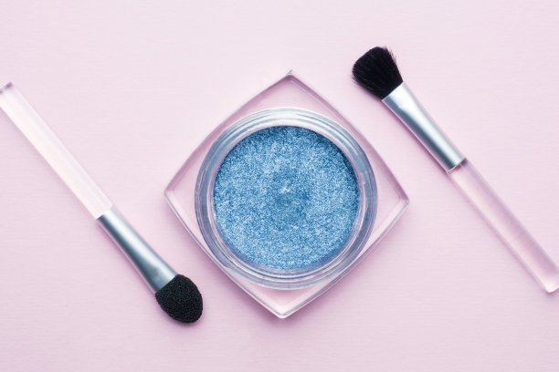粉彩背景上带流苏的蓝色眼影。美容化妆理念图片下载
