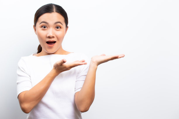 快乐的女人已经惊讶和指向拷贝空间孤立的白色背景图片下载