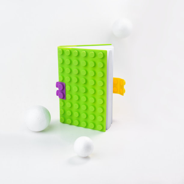 由亮绿色笔记本和白色小球组成的创意布局。静物生活、商业、办公用品或教育办学理念。复制空间，垂直，水平，关闭图片下载