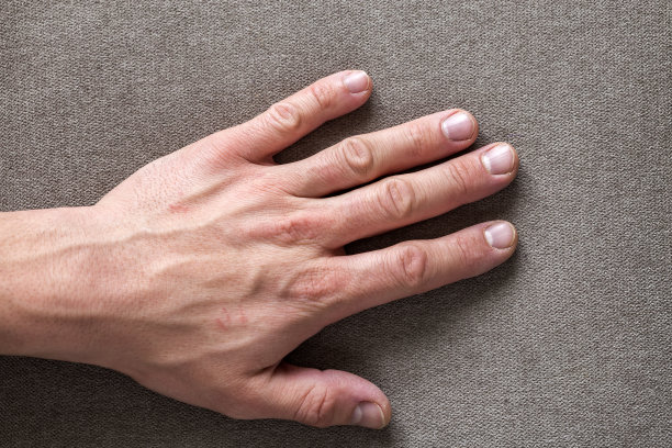 男性男性的手的特写与粗糙的皮肤和短指甲休息在平面复制空间背景，俯视图。手工劳动和双手护理理念。图片下载