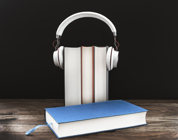 有声书概念与耳机精装书在木桌上对黑暗的背景图片下载