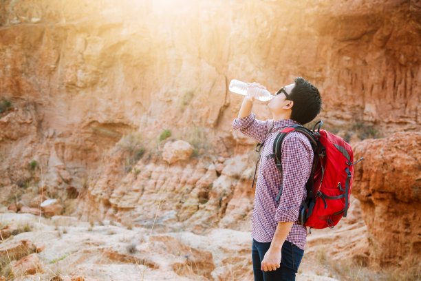 从瓶子里喝水的人。图片下载