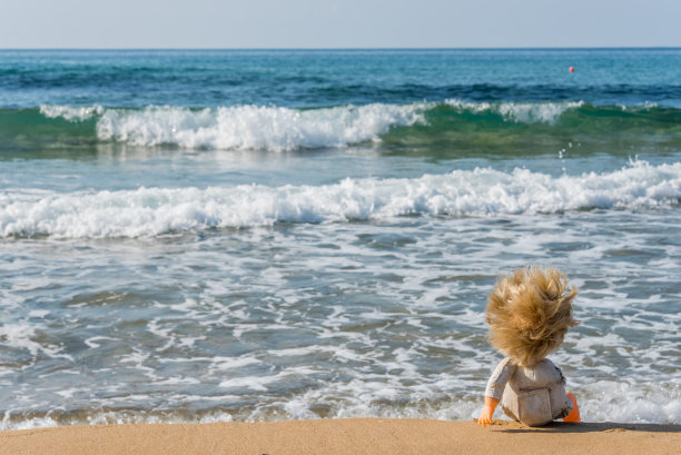 一个阳光明媚的日子里，一个旧玩具娃娃坐在意大利南部的海滩上图片下载