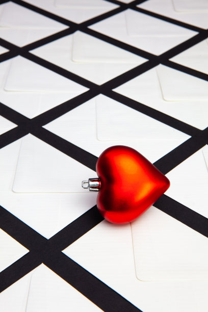 桌上有白色信封和红心的构图。图片下载