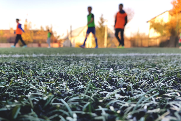 用一条白色条纹和模糊的足球作为背景关闭人工草坪图片下载