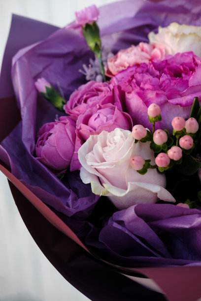 粉红色和紫色的玫瑰花束。一个女人正在花店准备花束。关闭了。母亲节和情人节的概念图片下载