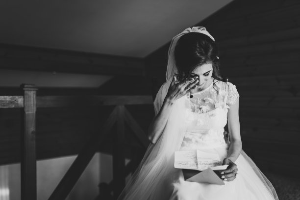 美丽的新娘为爱读着新郎的来信。新娘的眼泪，幸福的喜悦。新娘坐在窗边，给新郎读信。结婚誓言。新娘的早晨。黑白照片。图片下载