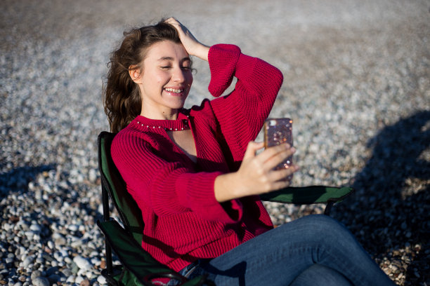 一名年轻女子在海滩自拍图片下载