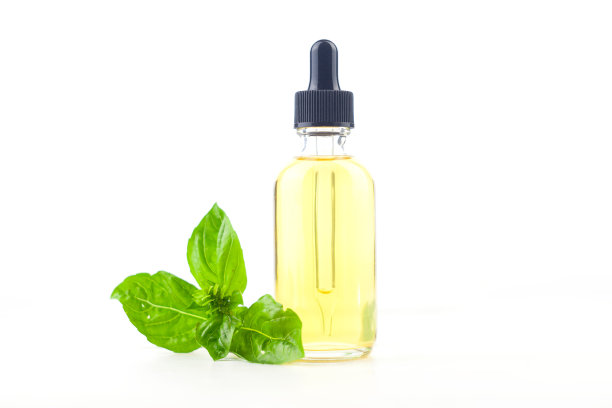 罗勒精油在美丽的瓶子在白色的背景图片下载