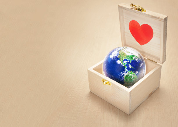在木背景、地球日和拯救地球的概念上，木盒子里的红色心形玻璃球图片下载