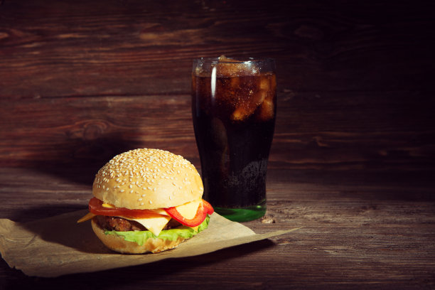 木桌上放着自制的汉堡包和可乐图片下载