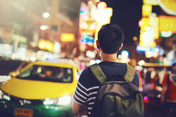 年轻的亚洲男性旅行背包客走在街上的中国城，曼谷，泰国-亚洲旅游的概念。图片下载