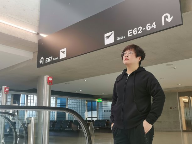 一位亚洲华裔女性在机场看时刻表图片下载