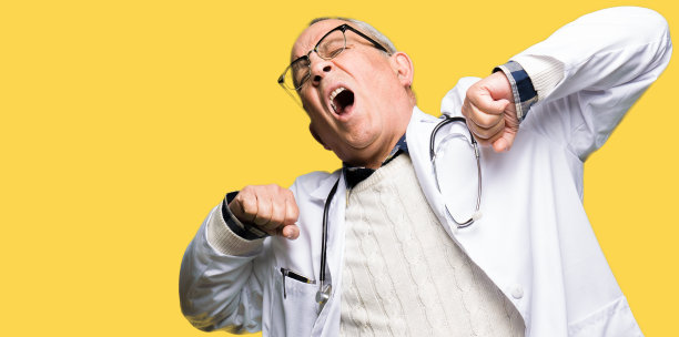 帅气的资深医生男人穿着医用大衣舒展着身体，疲惫又放松，清晨困倦又打呵欠图片下载