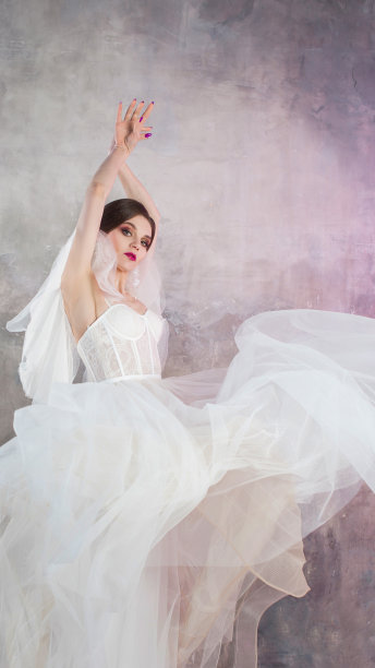 美丽和时尚的新娘在婚礼礼服与郁郁葱葱的飞裙图片下载