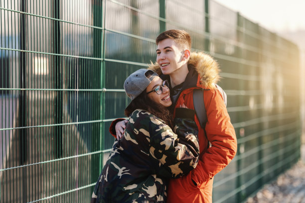 可爱的多元文化情侣在春天的户外拥抱。图片下载