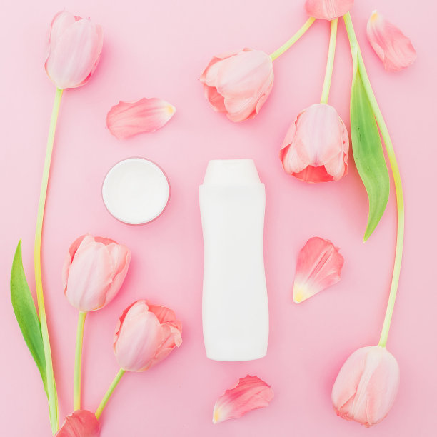 粉色背景上的香波和白色郁金香花。美丽的概念。平躺，俯视图图片下载