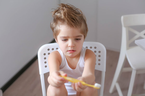男孩在早上清洁牙齿，然后用牙刷玩图片下载