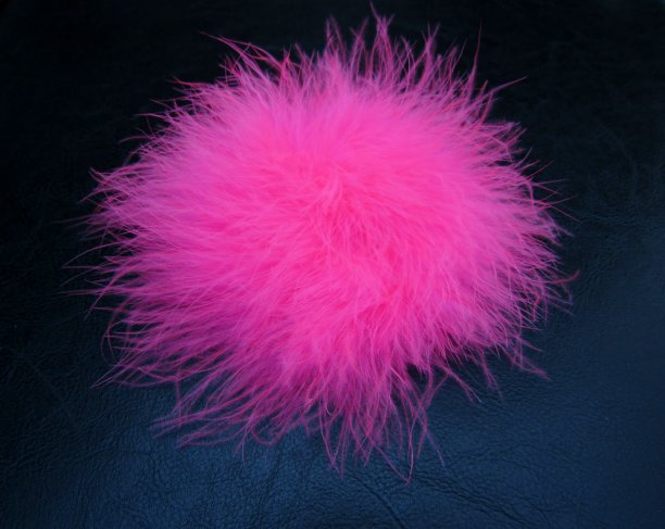 黑色背景上的粉红色蓬松的羽毛球图片下载