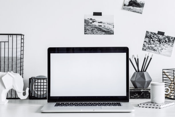 时尚的黑白家居装饰与模拟笔记本电脑屏幕。创意办公桌与照片，书桌物件，办公用品，一杯咖啡和大象的白色背景。图片下载